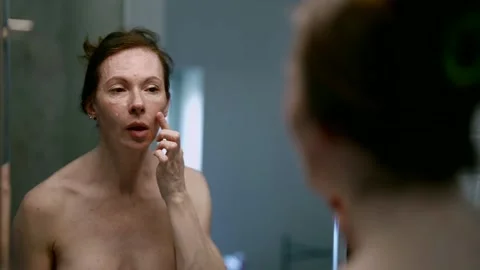 Devoted to her beauty ritual, a middle-aged adult woman takes time to take care Stock Footage 274876964