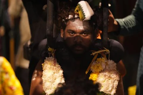Devotee bearing ceremonial framework adorned with flower garlands Stock Photos