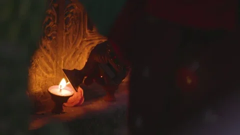 Devotee burning a oil lamp in temple Stock Footage 77453537