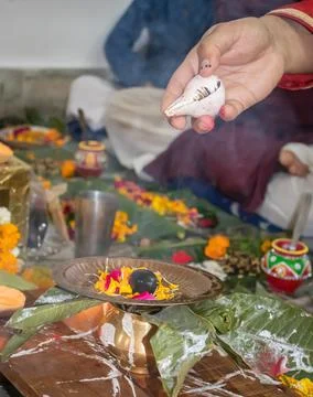 Devotee doing religious ritual of holy god with conch shell and blurred backg Stock-Fotos