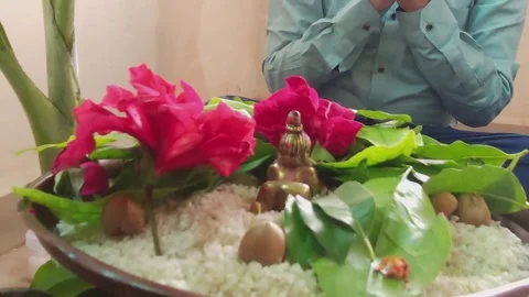 Devotee in a formal shirt sitting in a namaskar prayer posture behind a brass Ba Stock Footage 346017842
