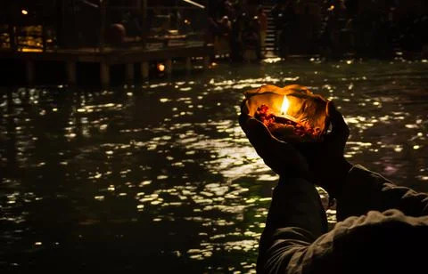 Devotee holding aarti flower pot for ganges river evening prayer at night Stock Photos