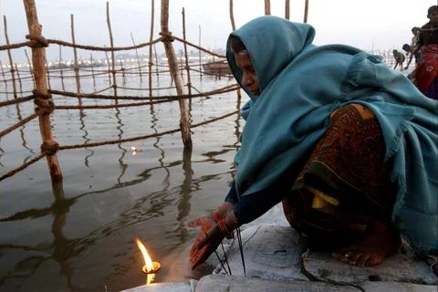 A devotee perform Ganga Aarti at the confluence of the Ganges, Yamuna and ... Stock Photos