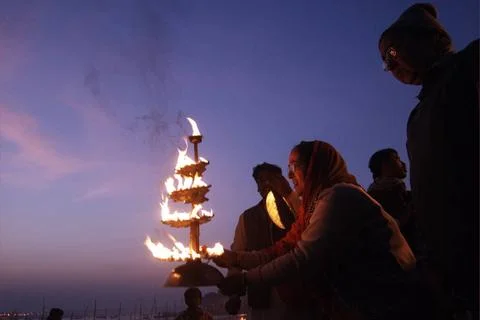 A devotee perform Ganga Aarti at the confluence of the Ganges, Yamuna and ... Stock Photos