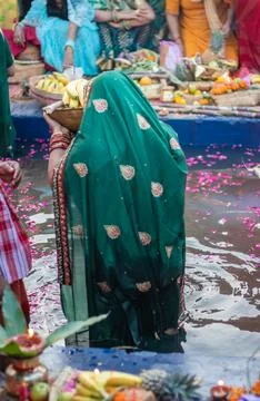 Devotee praying with religious offerings for sun god in Chhath festival Stockfoto's