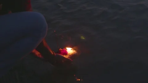 Devotee putting the religious offerings in the river Stock Footage 77452183