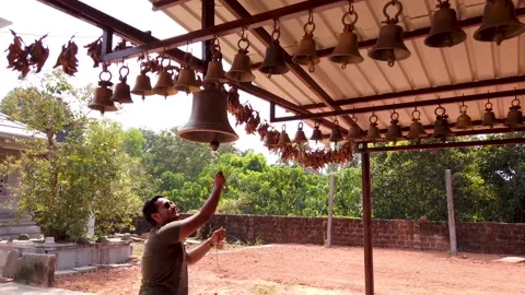A Devotee is seen ringing the brass bells of  at a Jain temple in India. Stock Footage 153320047