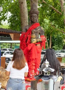 Devotees at a Decorated Religious Statue with Red Garlands Stock Photos