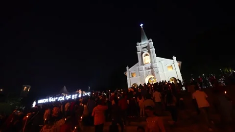 Devotees experience the a glow of devotion through candle blessings Vídeos de archivo 255420082