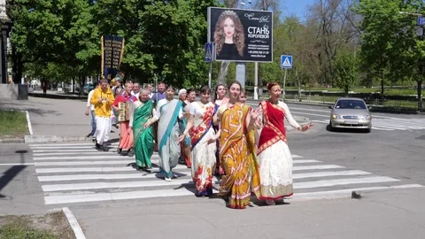 Devotees from Hare Krishna dancing with carnival revelers during the Vaishnava Stock Footage 77865664