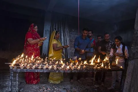 Devotees lighting lamps Stock Photos