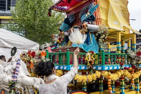 Devotees offering prayers below an ornate float Stock-Fotos