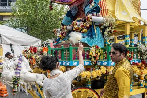 Devotees offering prayers below an ornate float Stock Photos