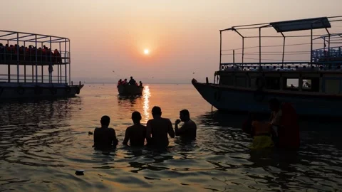 Devotees performing spiritual bathing ritual at dawn on peaceful ganges river 库存影片 335442280