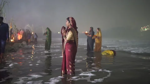 Devotees praying In Polluted Yamuna River's Toxic Foam For Chhath Puja Rituals Stock Footage 165064452