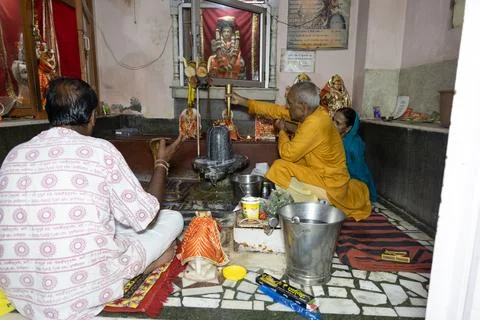 Devotees with priest Performing Lord Shiva Lingam Abhishek Ritual Inside Te.. Stock Photos