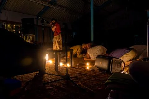 Devotees in prostration during kirtan performance with singer and audio Stock Photos
