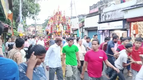 Devotees pulling decorated Rath Yatra chariot on busy street in Howrah Stock Footage 340826030