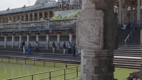 Devotees Sitting and Washing Feet on Stone Steps of Sacred Temple Tank at Stock Footage 338019897