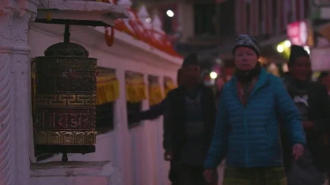 Devotees spinning prayer wheels outside a Tibetan Buddhist temple in Kathmandu Stock Footage 77453561