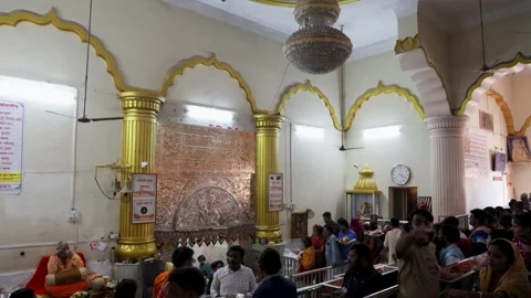 Devotees standing in queue for darshan inside crowded hindu temple hall Stock Footage 321880106