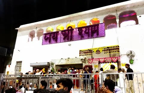 Devotees standing in queue with roses inside Khatu Shyam temple Stock Photos