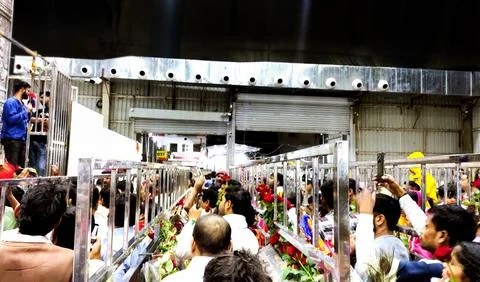 Devotees standing in queue with roses inside Khatu Shyam temple Stock Photos