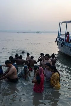 Devotees taking holy dip in ganga river during spiritual ritual in varanasi Stock Photos