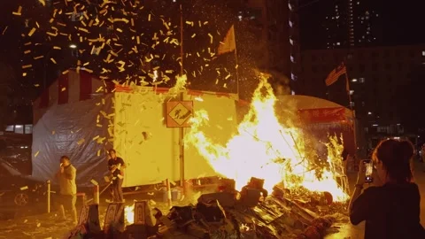 Devotees Throwing Joss Paper Confetti Over Large Bonfire during Hungry Ghost Stock Footage 345995203