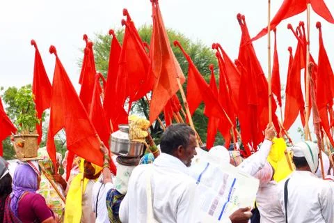 Devotees walking in a pilgrimage carrying various orange color flags Stock Photos