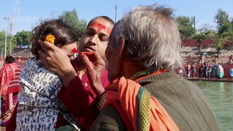 Devotional Tilak Ritual with Child and Elders During Religious Pilgrimage in Stock Footage 340814536