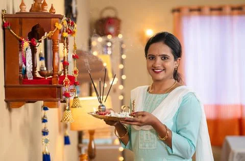 Devotional young girl looking camera after offering aarthi with incense sticks Stock Photos