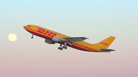 Dhl cargo airplane taking off side view panning left passing tower moon Stock Footage 153069100