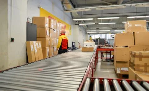 DHL delivery worker cheking package boxes Stock Photos