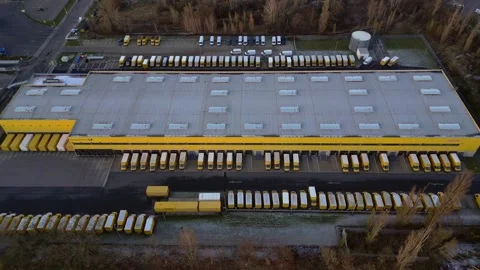 DHL Deutsche Post logistics center with delivery vans. Majestic aerial view Stock Footage 323257992