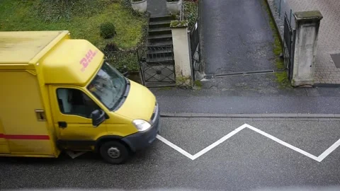 DHL Deutsche Post minivan with company logos driving away Video stock 148554533