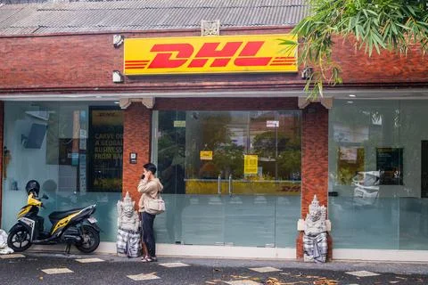 DHL Express Storefront with Balinese Statues and Scooter Stock-Fotos