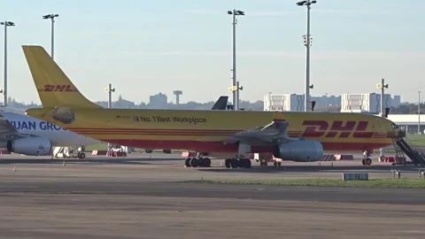 DHL Freight Cargo Parcel Delivery on time Airbus A330 cargo parked at airport Stock Footage 240295385