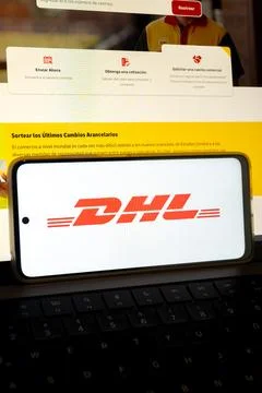 Dhl logo displaying on cellular device above keyboard Stock Photos