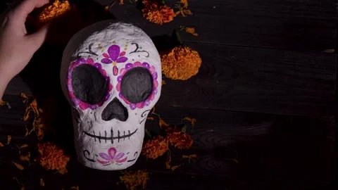 Dia de Muertos Sugar Skull Decor on Dark Wood with Marigold Petals and Hands Stock Footage 343544430