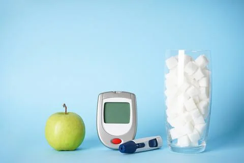 Diabetes concept. Digital glucometer, lanceolate pen, sugar in a glass and an Stock Photos