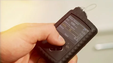 Diabetic man with an insulin pump connected in his abdomen and holding the insul Stock Footage 117502020