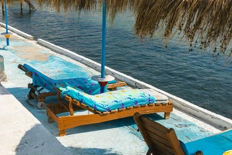 Diagonal Angle View of Sunbeds and Palm Umbrella in Durres Albania Foto stock