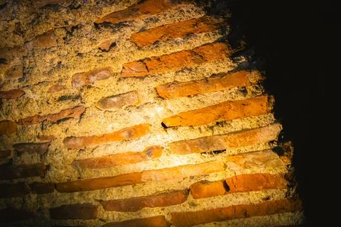 Diagonal brick pattern illuminated by spotlight in ancient historical site .. Stock Photos