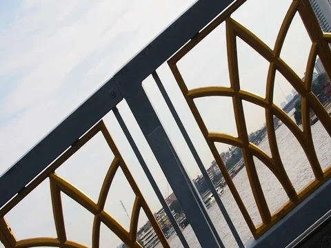 Diagonal bridge fence with transporting boats on brown river Stock Footage 80760552