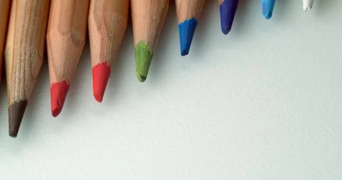 Diagonal colour pencils rolling off top of frame Stock Footage 113142828