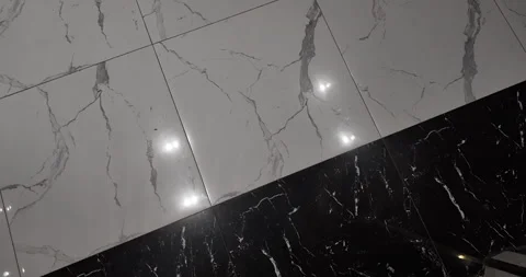 Diagonal contrast of white and black marble tiles reflecting flickering lights. Stock Footage 335950941