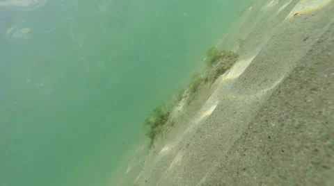 Diagonal frame sand at the bottom with patches of sun and clear sea water Stock Footage 42628098
