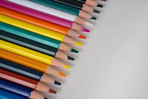 Diagonal line of sharpened colored pencils on clean white background Stock Photos