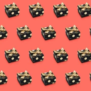 Diagonal lines of black wrapped present boxes on living coral color backgroun Illustrazione stock